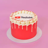Corporate Drip Cake with Logo featuring a red drip design and edible YouTube logo plaque on top by Crumbs & Doilies
